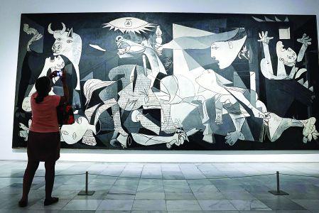 Una persona aprecia el cuadro Guernica, de Pablo Picasso, en el Museo Reina Sofía, en Madrid, España.