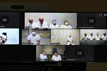 Pantallas muestran a acusados de MS-13 conectados a audiencia virtual desde cárceles en El Salvador durante juicio masivo en Soyapango.