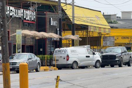 Unidad del Semefo estacionada frente a un bar en Reynosa, Tamaulipas, con vehículos y zona acordonada tras un crimen reportado.