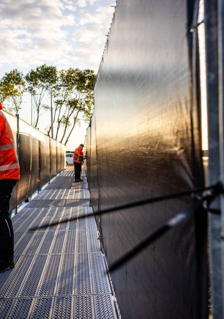 Empleados instalan barreras en el puerto de Róterdam antes del arribo del crucero MV Hondius afectado por un brote de hantavirus.
