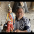Alejandrino García Méndez, maestro de los voladores de Papantla, sostiene una figura tradicional del danzante dentro de un espacio comunitario en Veracruz.
