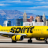 Avión de Spirit Airlines en pista de aeropuerto con fuselaje amarillo y ciudad de fondo, identificado como aerolínea de bajo costo en Estados Unidos.