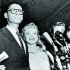 Arthur Miller y Marilyn Monroe son abordados por la prensa.