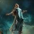 Carrie White con vestido azul claro, suspendida en el aire mientras objetos flotan a su alrededor bajo un cielo oscuro.