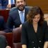 Isabel Díaz Ayuso sonríe durante su intervención en la Asamblea de Madrid, mientras miembros del pleno reaccionan con risas a su comentario irónico sobre el adelanto de la Navidad en Venezuela.