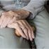 Anciano sujetando un bastón con su mano