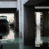 Estacionamiento subterráneo en la colonia Agrícola Pantitlán, Ciudad de México, completamente inundado tras lluvias intensas. Varios autos, con cofres abiertos y marcas de agua, permanecen sumergidos a media altura mientras un trabajador de la alcaldía realiza labores de desazolve.