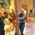 Un curador de museo manipula cuidadosamente un gran cuadro de Pierre-Auguste Renoir en una galería de arte. La pintura muestra una escena familiar con varias figuras, incluyendo niños y adultos, en un entorno natural. Al fondo se aprecian más obras colgadas, lo que sugiere una exposición dedicada al impresionismo o al arte europeo del siglo XIX.