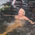Mujer sumergiéndose en agua helada durante festival Vodohreshya en Kyiv Urania