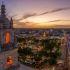 Panorámica aérea del centro histórico de Mérida, Yucatán, al atardecer, con la catedral y edificios coloniales iluminados, mostrando el entorno urbano y la actividad de la ciudad.