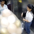 Dos personas dentro de un ascensor en Mumbai observan una gran cantidad de globos que estallan repentinamente, generando una explosión y una nube de gas en un espacio cerrado, según un video de seguridad.
