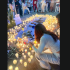 Personas vestidas de blanco encienden velas alrededor de un memorial con fotografías y flores durante una concentración por la paz en el Parque Sendela, en Angelópolis, Puebla, tras la balacera frente al bar Sala de Despecho.