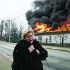 (FILES) A woman reacts as she stands in front of a house burning after being shelled in the city of Irpin, outside Kyiv, on March 4, 2022. More than 1.2 million people have fled Ukraine into neighbouring countries since Russia launched its full-scale invasion on February 24, United Nations figures showed on March 4, 2022. (Photo by Aris Messinis / AFP)