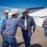 Álvaro Iván Bustillos Fuentes conversa y saluda a ganaderos durante una asamblea regional de la UGRCH en Chihuahua, en un espacio al aire libre con productores portando sombrero vaquero.