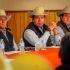 Dirigente ganadero con sombrero vaquero sentado en mesa de reunión junto a otros representantes del sector, con botellas de agua y asistentes al frente.