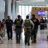 Immigration and Customs Enforcement (ICE) agents walk at Newark Liberty International Airport, as hundreds of them were ordered to deploy to airports to help fill TSA staffing gaps, in Newark, New Jersey, U.S., March 23, 2026. REUTERS/Jeenah Moon
