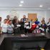 Grupo de habitantes y autoridades de Iztacalco muestran cheques de apoyos económicos en sala de juntas de la alcaldía tras afectaciones por lluvias.