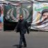 Un hombre pasa junto a pancartas colocadas a lo largo de la carretera con la imagen del ayatolá Ali Khamenei