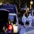 Peritos forenses con trajes blancos caminan junto a vehículos policiales en Leipzig durante la investigación del atropello en zona peatonal