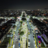 Vista aérea nocturna de Ecatepec con avenidas iluminadas, camellones y viviendas tras el programa de alumbrado público.
