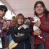 Tres jóvenes sostienen dos cachorros y un gato durante una jornada de esterilización gratuita y bienestar animal en el Estado de México.