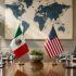 Mesa de reunión diplomática con banderas de México y Estados Unidos previo a conversaciones formales sobre la revisión del T-MEC en la Secretaría de Economía.