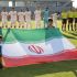La selección de Irán detrás de su bandera previo a un partido.
