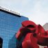 Vista del edificio corporativo de Banco Azteca con su logotipo en la parte superior y una escultura roja en primer plano.
