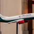 Modelo a escala de un avión de Mexicana de Aviación con los colores institucionales, exhibido sobre un soporte durante un evento.