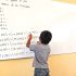 Un alumno de educación básica resolviendo un ejercicio en un pizarrón.