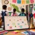 Estudiantes de espaldas en una escuela de México junto a un calendario escolar, útiles y la bandera mexicana.