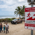 Cartel de alerta sísmica y evacuación por tsunami en una playa de Chiapas tras el sismo de magnitud 7.4.