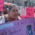 Mujer protestando con pancartas que muestran la fotografía de Dafne Zapata con las frases "Era solo una niña" y "Justicia para Dafne".