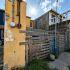 Fachada de una vivienda en Matamoros, Tamaulipas, con paredes deterioradas, medidores de servicios y una cerca de madera.