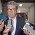 Ricardo Monreal responde preguntas de reporteros durante una entrevista en un pasillo, acompañado por otros asistentes y varios micrófonos.