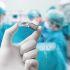 Un profesional sanitario sostiene un implante coclear durante un procedimiento médico, mientras varios especialistas trabajan en un quirófano.