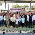 Autoridades, productores y habitantes participan en una entrega de apoyos agrícolas con plantas e insumos colocados frente al grupo.