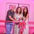 Tres personas inauguran Stella Rosa Summer Experience frente a un escenario rosa, durante el corte de listón en Ciudad de México.