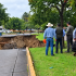 Autoridades y civiles observan el mega socavón que colapsó parte del asfalto y áreas verdes en la avenida Malecón, Tonalá.