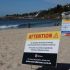 Playa de Australia Occidental con señales de advertencia y vigilancia aérea mediante drones frente a la costa, tras un ataque de tiburón.