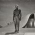 Visitante extraterrestre de pie frente a una nave espacial en una escena de El día que la Tierra se detuvo, película de 1951.