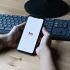 Persona sostiene un celular con Gmail abierto para recuperar una cuenta de correo electrónico.