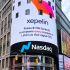 Anuncio de Xepelin en una pantalla de Nasdaq en Nueva York, con edificios y calles del distrito financiero al fondo.