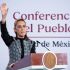 La presidenta Claudia Sheinbaum levantando la mano desde el atril durante la Conferencia del Pueblo sobre temas energéticos.