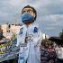 Marcha de trabajadores del IMSS y agremiados del SNTSS exigiendo un salario digno, acompañados de una figura gigante de un trabajador de la salud con cubrebocas.