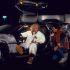 Doc Brown sentado en el DeLorean conversa con Marty McFly durante una escena nocturna de Volver al futuro.