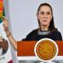 La presidenta Claudia Sheinbaum hablando desde el atril presidencial con el escudo de los Estados Unidos Mexicanos, teniendo la bandera de México de fondo.