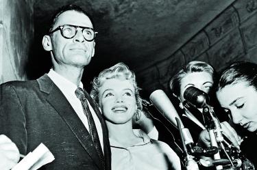 Arthur Miller y Marilyn Monroe son abordados por la prensa.