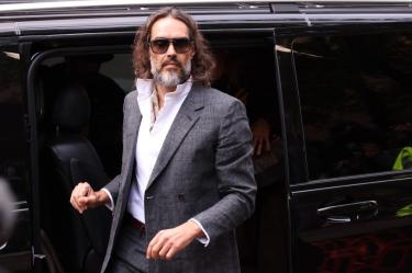 British comedian and actor Russell Brand arrives for the start of his trial at Southwark Crown Court in south London on October 12, 2026, after pleading not guilty to three charges of rape, indecent assault, and three counts of sexual assault. (Photo by Brook Mitchell / AFP)