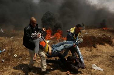 Manifestantes palestinos evacúan a un herido durante una protesta en la frontera de Gaza con Israel.